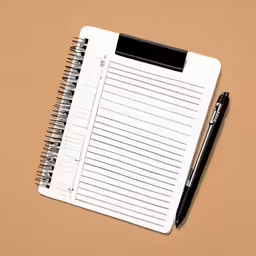 a notepad and pen are sitting on a desk