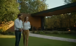 two people are walking through the grass