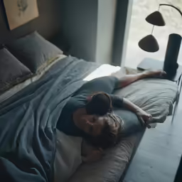 a young girl is laying on her stomach in a bed