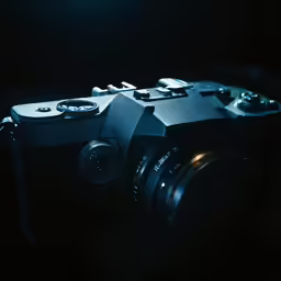camera in dark scene with lens pointed towards flash