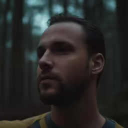 the man is in a forest with tall trees
