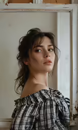 a woman in plaid blouse leaning against an old window