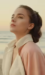 a woman with a towel wrapped around her neck by the beach