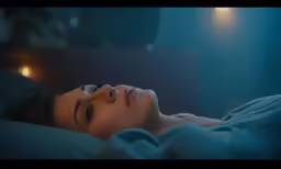 a woman is laying in bed in the middle of the night
