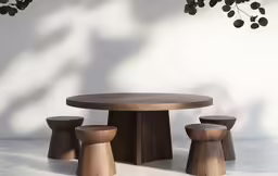 three small round wooden stools sitting on top of a white table