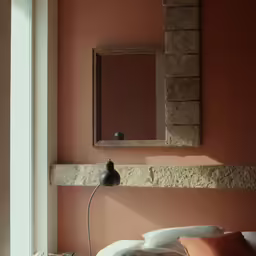 the bed is next to the wall mounted mirror