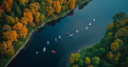 the boats are traveling on the water by some trees