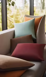 multiple colored pillows are arranged on a couch