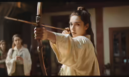 a woman with long black hair holding a bow in her hand