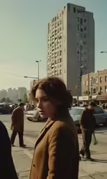 woman standing on the sidewalk near a crosswalk