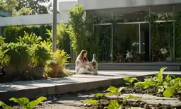 a lady sitting on a patio with an umbrella