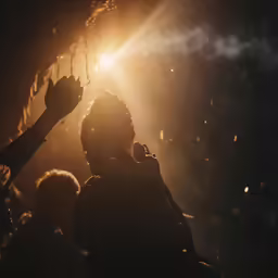people standing around talking and holding hands up