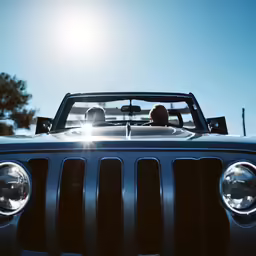 a jeep is parked while the sun shines