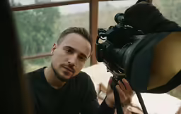 a man taking a picture next to a camera
