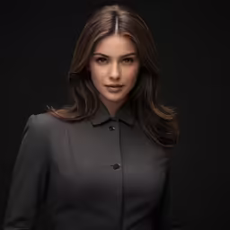 a woman in a grey coat and skirt posing