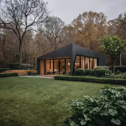 black building with glass walls on top surrounded by a lush green lawn