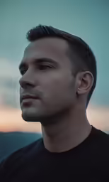 a man with short hair looking off to the side
