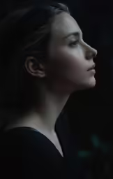 a woman with eyes closed staring intently at something