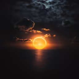 a sunset behind a very large body of water