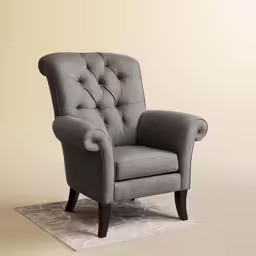 a gray upholstered chair sits on a rug