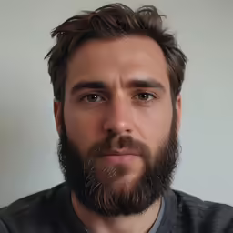 a man with a beard and grey shirt