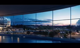 the windows of an office building at dusk reflecting planes