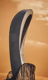 a strange shaped object with some large rocks behind it