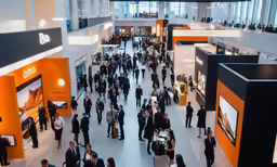 a large crowd of people walk around an exhibit