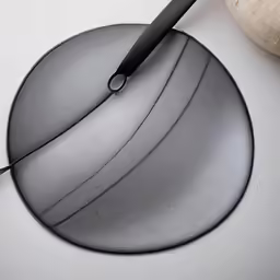 a knife cutting a circle shape with a long blade