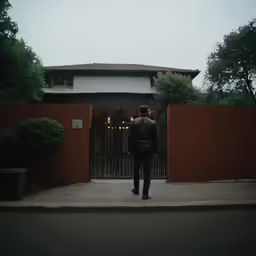 a man standing in front of a gate with an iron gate