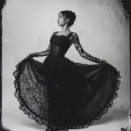 an old black and white photo of a woman wearing a dress