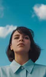 a young woman in a blue shirt stares upwards in the air