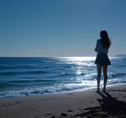 a beautiful woman standing on top of a sandy beach