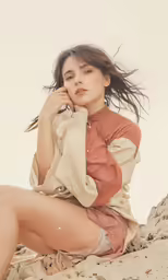 a woman posing on the beach in shorts