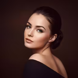 woman with brown eyes and dark background wearing an elegant updo