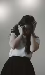 the young woman in the skirt covers her eyes