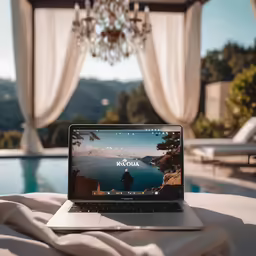 a laptop computer sitting on a blanket near a pool