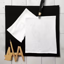 two paper clips on a piece of cloth and a wooden cutter