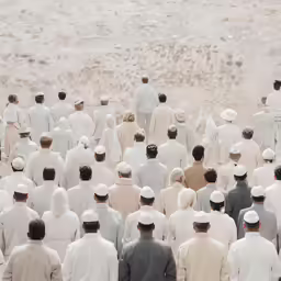 a group of people standing in front of sand