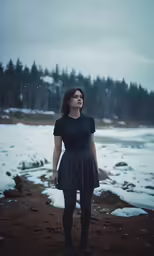 a woman wearing black stands in a snowy landscape