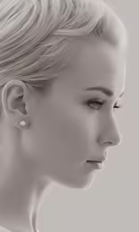 black and white photograph of woman in profile with ear studs