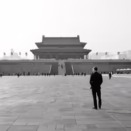 a man wearing a hat standing in front of a building