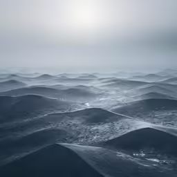 a hazy and foggy scene with several hills