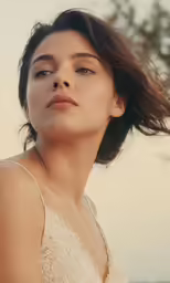 a woman with brown hair wearing a white dress