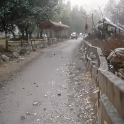 a fence and street with houses behind it