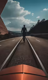 a man walks on the empty road toward a hill