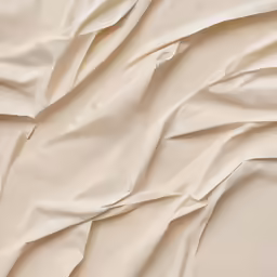 a bed with a white sheet that is wavy