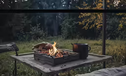 a person is setting up a campfire on the picnic table