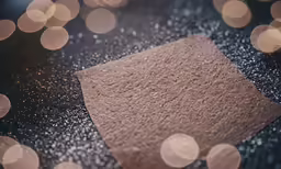 a square brown paper and glittered boke is sitting on a table