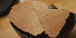 several pieces of brown tissue sit in a black cup